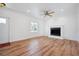 Bright living room featuring hardwood floors, fireplace, ceiling fan, and ample natural light at 121 Dolly St, Punta Gorda, FL 33950