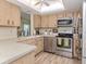 This kitchen features stainless steel appliances, wood cabinets, ample counter space, and stylish decor at 1231 Pine Needle Rd, Venice, FL 34285