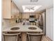 Well-lit kitchen with stainless steel appliances, wood cabinets, and a cozy breakfast bar with seating at 1231 Pine Needle Rd, Venice, FL 34285