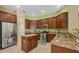 Well-lit kitchen features stainless appliances, granite counters and tiled floor at 1241 Creek Nine Dr, North Port, FL 34291