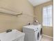 Functional laundry room includes a washer, dryer, sink, and storage shelf at 1241 Creek Nine Dr, North Port, FL 34291