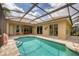 A view of the refreshing screened-in pool with its tile surround and multiple access points to the residence at 1241 Creek Nine Dr, North Port, FL 34291