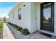 A welcoming front entrance of a villa showcasing the sleek door and manicured plants at 12418 Asana Ct, Venice, FL 34293