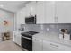 A kitchen with white cabinets, gray backsplash, stainless steel appliances, and quartz countertops at 12418 Asana Ct, Venice, FL 34293
