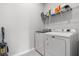 Bright laundry room with modern washer, dryer, shelving, and cleaning supplies at 12418 Asana Ct, Venice, FL 34293