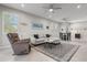 Spacious living room featuring a comfortable sectional sofa, a recliner, and large windows at 12418 Asana Ct, Venice, FL 34293