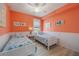 Charming bedroom featuring twin beds, white wainscoting, and bright orange walls with nautical decor accents at 12500 Ghiberti Cir # 101, Venice, FL 34293