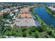 Aerial view of a lakeside property with screened in pool, lush landscaping, and serene water views at 13150 Huerta St, Venice, FL 34293