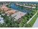 Aerial view of the house with a pool, lush landscaping, and a serene lake in the community at 13150 Huerta St, Venice, FL 34293
