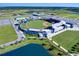 Aerial view of a baseball stadium surrounded by lush greenery and ponds on a sunny day at 13150 Huerta St, Venice, FL 34293