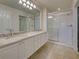Bright bathroom featuring marble vanity, bright lights and a glass enclosed shower with white tile at 13150 Huerta St, Venice, FL 34293
