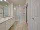 Bathroom featuring marble vanity, bright lights and a glass enclosed shower with white tile at 13150 Huerta St, Venice, FL 34293
