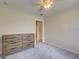 Neutral bedroom with hardwood dresser, neutral walls and carpet; ceiling fan and white trim at 13150 Huerta St, Venice, FL 34293