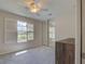 Bright bedroom featuring a ceiling fan, neutral walls, carpet, and a window with beautiful outdoor views at 13150 Huerta St, Venice, FL 34293