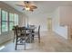 Bright dining area with a stylish ceiling fan and large windows, adjacent to the laundry room at 13150 Huerta St, Venice, FL 34293