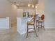 Bright kitchen area features white cabinets, stainless steel appliances, and bar seating at 13150 Huerta St, Venice, FL 34293