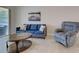 Cozy living room featuring a blue sofa, comfortable recliner, and stylish coffee table at 13150 Huerta St, Venice, FL 34293