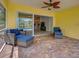 Inviting outdoor patio with brick flooring and wicker furniture, perfect for relaxing and enjoying the pool view at 13150 Huerta St, Venice, FL 34293