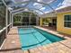 Screened-in pool with brick surround, offering a private oasis for relaxation and outdoor enjoyment at 13150 Huerta St, Venice, FL 34293