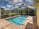 Inviting screened pool with brick pavers and clear views of a well-manicured lawn at 13150 Huerta St, Venice, FL 34293