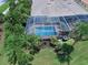 Aerial view of screened-in pool and patio area surrounded by lush tropical landscaping at 13150 Huerta St, Venice, FL 34293