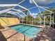 Screened pool with brick pavers and view of the lake surrounded by tropical landscaping at 13150 Huerta St, Venice, FL 34293