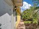 Charming side exterior with brick walkway, lush tropical landscaping, and inviting curb appeal at 13150 Huerta St, Venice, FL 34293