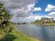 Scenic water view in the community, showcasing the canal, lush landscaping, and blue skies with fluffy white clouds at 13150 Huerta St, Venice, FL 34293