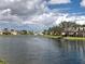 Scenic view of a peaceful lake, a bridge, and picturesque homes under a partly cloudy sky at 13150 Huerta St, Venice, FL 34293