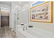 Modern bathroom showcases a luxurious soaking tub with tiled wall, alongside a glass-enclosed shower and walk-in closet at 13511 Esposito St, Venice, FL 34293