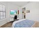 Inviting bedroom featuring a built-in desk, wood floors, and a serene view, blending comfort and functionality at 13511 Esposito St, Venice, FL 34293