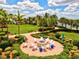Inviting outdoor fire pit area with comfortable seating and lush tropical landscaping in the Wellen Park community at 13511 Esposito St, Venice, FL 34293