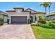 Charming exterior view of house with attractive landscaping and a brick paver driveway at 13511 Esposito St, Venice, FL 34293