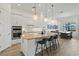 Open-concept kitchen with a large island, stainless steel appliances, and an adjacent dining area at 13511 Esposito St, Venice, FL 34293