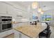 Bright kitchen with pendant lighting, granite countertops, and a view of the dining area at 13511 Esposito St, Venice, FL 34293