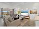 Bright living area with sliding glass doors to patio and connecting to the kitchen and bar at 13511 Esposito St, Venice, FL 34293