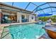 Beautiful pool with a water feature, outdoor seating, and an adjacent covered patio at 13511 Esposito St, Venice, FL 34293