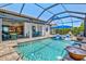 Stunning pool area featuring lush landscaping, relaxing loungers, and seamless flow to indoor living spaces at 13511 Esposito St, Venice, FL 34293