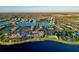 An aerial view captures a stunning community with water views, a community pool, clubhouse, and tennis courts at 13872 Rinuccio St, Venice, FL 34293