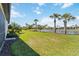 Expansive backyard with a scenic pond view, framed by palm trees and manicured landscaping at 13872 Rinuccio St, Venice, FL 34293