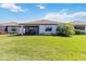 Lush backyard with well-maintained lawn, mature landscaping, and screened patio area at 13872 Rinuccio St, Venice, FL 34293