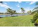 Picturesque backyard with a serene lake view, adorned with swaying palm trees and lush greenery at 13872 Rinuccio St, Venice, FL 34293