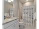 Clean bathroom featuring a granite countertop vanity, toilet, and shower with a themed curtain at 13872 Rinuccio St, Venice, FL 34293