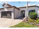 Charming home featuring a well-manicured lawn, paver walkway, and two-car garage at 13872 Rinuccio St, Venice, FL 34293