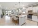 Open-concept kitchen with white cabinets, granite countertops, and stainless steel appliances overlooking the living area at 13872 Rinuccio St, Venice, FL 34293
