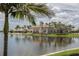View of Toscana Isles' clubhouse surrounded by a lake, palm trees, and well manicured landscaping at 149 Vinadio Blvd, Nokomis, FL 34275