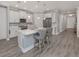 Modern kitchen with white cabinetry, stainless steel appliances, and counter seating at 149 Vinadio Blvd, Nokomis, FL 34275