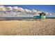 A charming green lifeguard stand stands guard over a pristine sandy beach with gentle ocean waves at 149 Vinadio Blvd, Nokomis, FL 34275