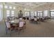 A sunlit meeting room features a stone fireplace, chandelier, and ample seating with round tables and upholstered chairs at 149 Vinadio Blvd, Nokomis, FL 34275