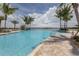 Community outdoor pool with shaded lounge chairs and palm trees in Toscana Isles at 149 Vinadio Blvd, Nokomis, FL 34275